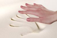 Hand über einem Abdruck im viskoelastischen Memory-Schaum – der Abdruck bleibt kurzzeitig sichtbar und zeigt die Anpassungsfähigkeit des Materials